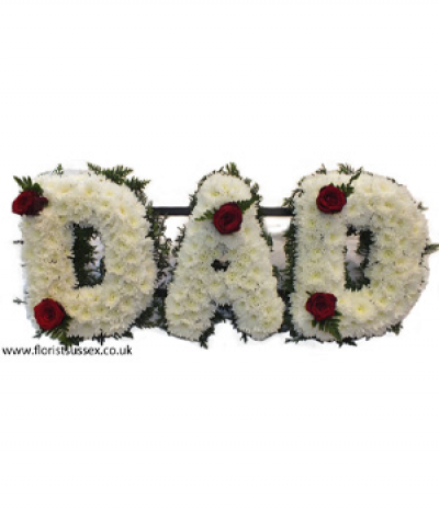DAD 02 - Lettering "Dad" massed in white chrysanthemums, finished with red roses dotted through and framed with green foliage edging. Any wording can be created in this style, and colours can be altered to suit your preferences- please call us to discuss.