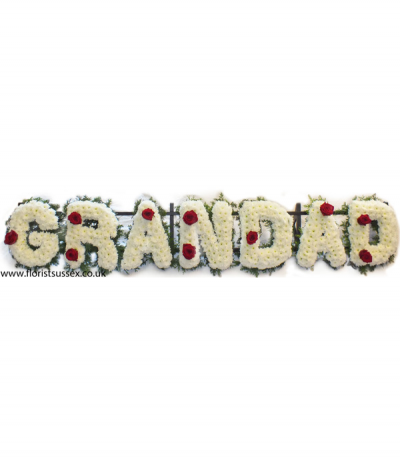 Grandad 2 - Lettering "Grandad" massed in white chrysanthemums, finished with red roses dotted through and framed with green foliage edging. 
Any wording can be created in this style, and colours can be altered to suit your preferences- please call us to discuss your requirements.
£45.00 per letter.