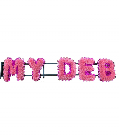 "My Deb" - Lettering based in pale pink carnations as an alternative to chrysanthemums, and finished with cerise-pink pleated ribbon edging.
Any wording can be created in this style, and colours can be altered to suit your preferences- please call us to discuss.
£55.00 per letter.