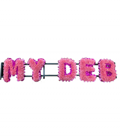 "My Deb" - Lettering based in pale pink carnations as an alternative to chrysanthemums, and finished with cerise-pink pleated ribbon edging.
Any wording can be created in this style, and colours can be altered to suit your preferences- please call us to discuss.
£55.00 per letter.