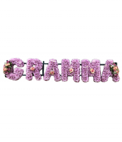 Six-letter name tribute (Gramma) - Lettering "Gramma" massed in pink chrysanthemums, finished with dainty pink and white sprays at each end and individual pink roses. 
Any wording can be created in this style, and colours can be altered to suit your preferences- please call us to discuss or note your six-letter name in the "any special requests" box to order online.
£45.00 per letter.