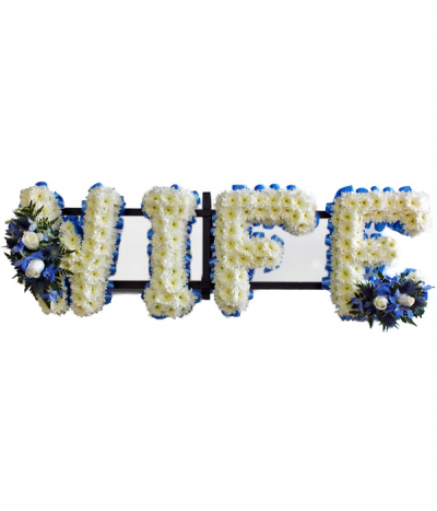 Wife 2 - "Wife" lettering based in white chrysanthemums, complimented with blue ribbon edging and two blue and white flower sprays.
Any wording can be created in this style, and colours can be altered to suit your preferences- please call us to discuss.
£45.00 per letter.