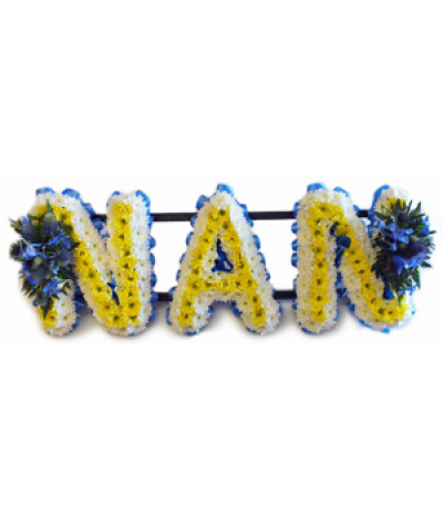 Nan 1 - Lettering "Nan" in yellow and white massed chrysanthemums and finished with two blue flower sprays and blue pleated ribbon edging. 
Any wording can be created in this style, and colours can be altered to suit your preferences- please call us to discuss.
£45.00 per letter.