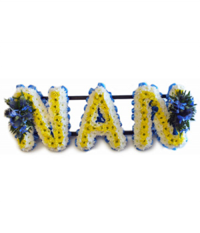 Nan 1 - Lettering "Nan" in yellow and white massed chrysanthemums and finished with two blue flower sprays and blue pleated ribbon edging. 
Any wording can be created in this style, and colours can be altered to suit your preferences- please call us to discuss.
£45.00 per letter.