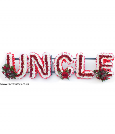 Uncle - "Uncle" lettering massed in deep red and white chrysanthemums, framed with red pleated ribbon edging and complimented with red flower sprays.
Any wording can be created in this style, and colours can be altered to suit your preferences- please call us to discuss.
£45.00 per letter.