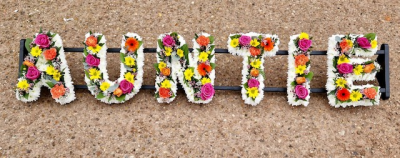 Auntie 2 - "Auntie" using both loose and massed floristry styles to create a beautifully colourful mixed selection alongside white massed chrysanthemums to give definition to the letters.
Any wording can be created in this style, and colours can be altered to suit your preferences- please call us to discuss. £45.00 per letter.