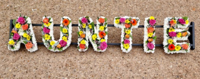 Auntie 2 - "Auntie" using both loose and massed floristry styles to create a beautifully colourful mixed selection alongside white massed chrysanthemums to give definition to the letters.
Any wording can be created in this style, and colours can be altered to suit your preferences- please call us to discuss. £45.00 per letter.