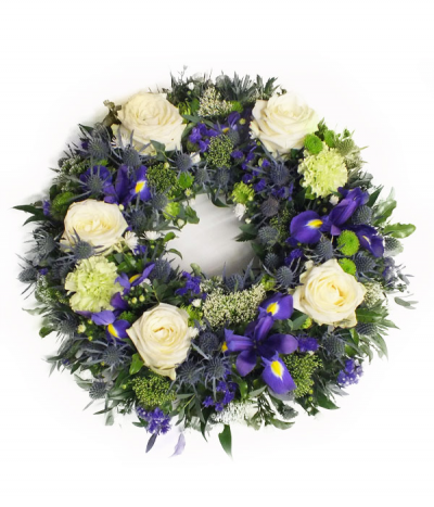 Graceful Wreath - An elegant wreath tribute in subtle purples, creams and greens. Featuring roses, iris (when in season), thistles, carnations and more, alongside natural foliages.