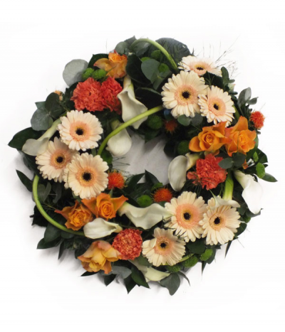 Contemporary Coppers Wreath - A classic wreath tribute with a contemporary twist- grouped gerberas and roses entwined with twisted calla lily stems and glossy leaves.