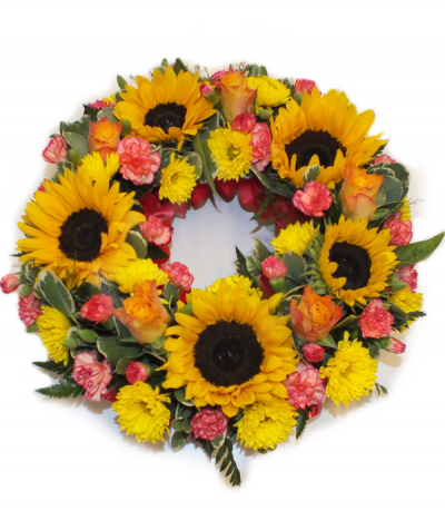 Sunshine Wreath - A sunny and bright tribute, this wreath incorporates sunflowers as a feature alongside orange roses and other orange and yellow mixed flowers to compliment.