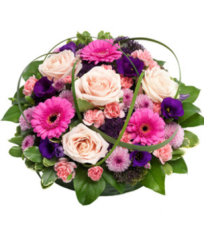 Pink & Purple Posy - A lovely pink and purple selection in a posy pad tribute, including gerberas, roses, carnations and lisianthus. Glossy leaves and looped grasses add texture to the design.