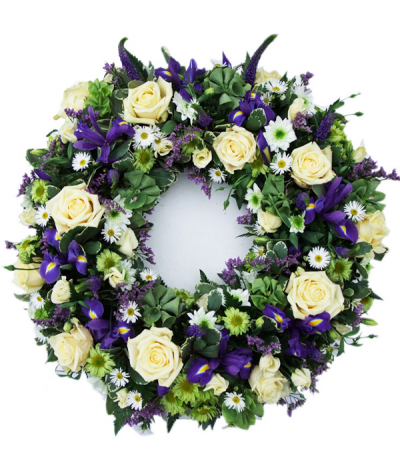 Raindrop Wreath - A beautiful purple and cream wreath tribute in a natural, loose style. Including roses, irises, veronica, daisy chrysanthemums and much more- nestled amongst seasonal foliage.