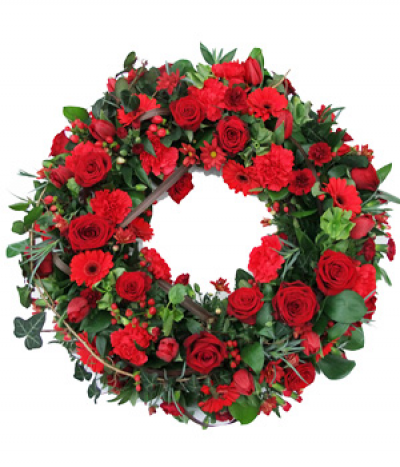 Red Velvet Wreath - A beautifully rich red floral wreath designed with the most luxurious red roses, gerberas, carnations, berries and much more