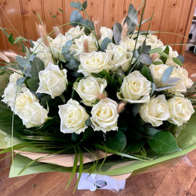 Platinum - A magnificent handtied bouquet in water presented in a gif bag/box. Created using all white roses flowers with complimentary foliage. Hand delivered with care in and around Littlehampton by Findon Flowers