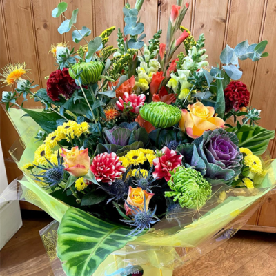 Lost in Wonderland - A marvellous handtied bouquet in water presented in a gif bag/box. Created using yellow, orange, red and white flowers with complimentary foliage. Hand delivered with care in and around Littlehampton by Findon Flowers